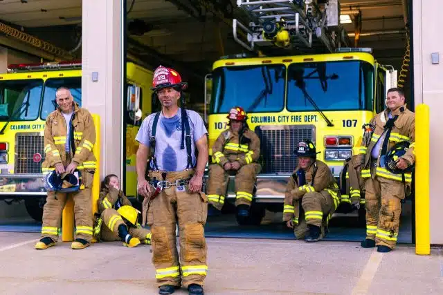 A firefighter standing in front of a firetruck at Columbia City Department preparing for a commercial campaign video.