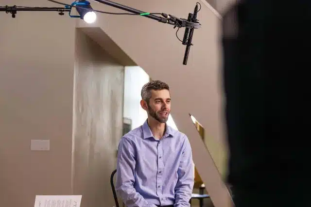 James Bausch sitting with a microphone over his head preparing for a commercial campaign at DreamOn Studios.