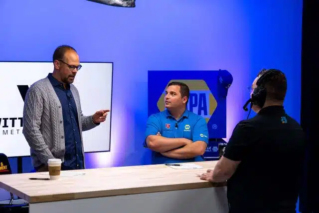 Man standing and man sitting behind a countertop area during a live stream for the Witt family in Warsaw, Indiana.