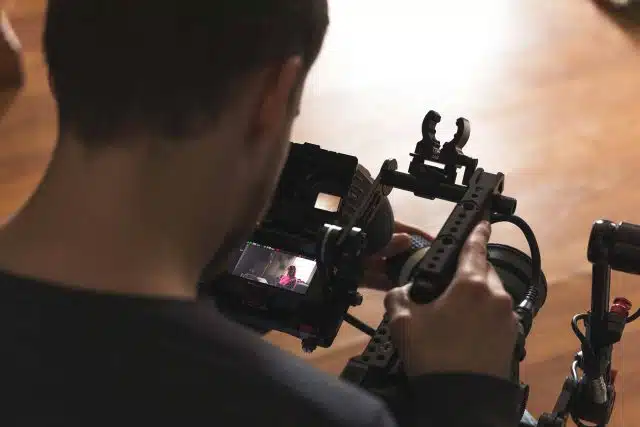 Closeup image on the back of a man's head looking down into a camera screen